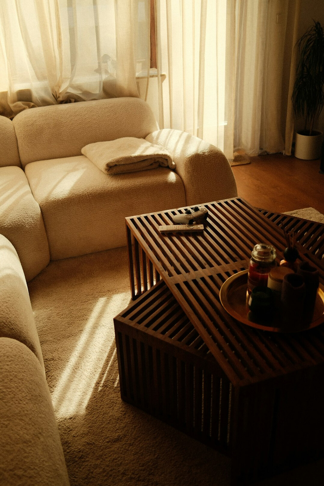 Cozy bright living room table with a smartphone, notebook, reading glasses and a cup of coffee in warm natural light